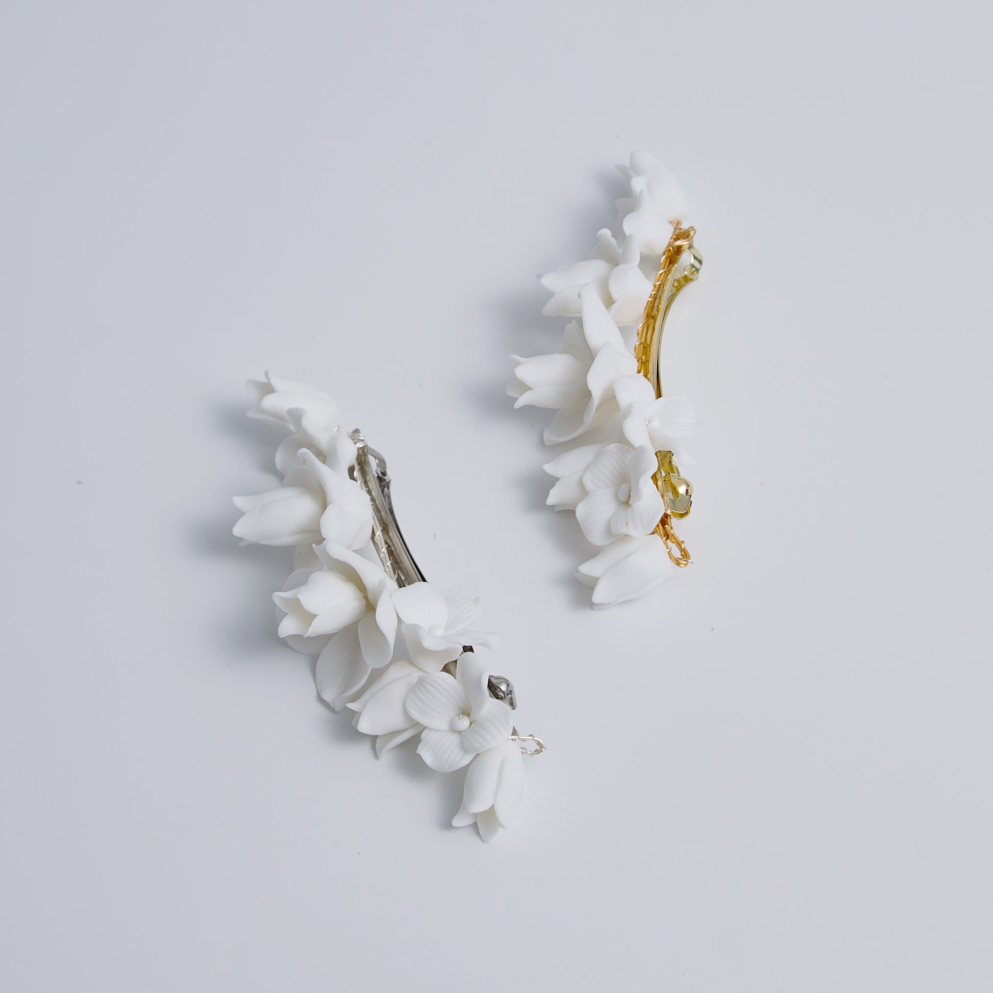 This statement bridal hair clip features carefully handcrafted white porcelain flowers and blossoms, adding an elegant and romantic touch to your hairstyle. It effortlessly enhances any bridal look, creating a timeless style.