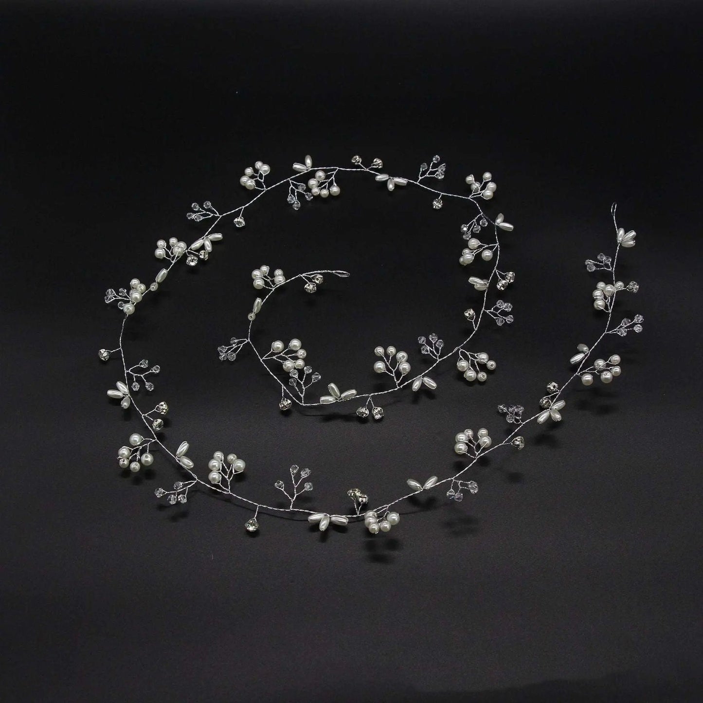 Silver bridal hair vine coiled to show its flexibility and delicate design