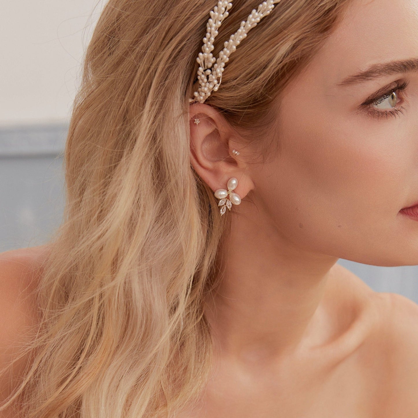 These stunning earrings feature leaf-like zirconia crystals that shimmer beneath three delicate pearls, evoking the graceful beauty of blooming flowers.