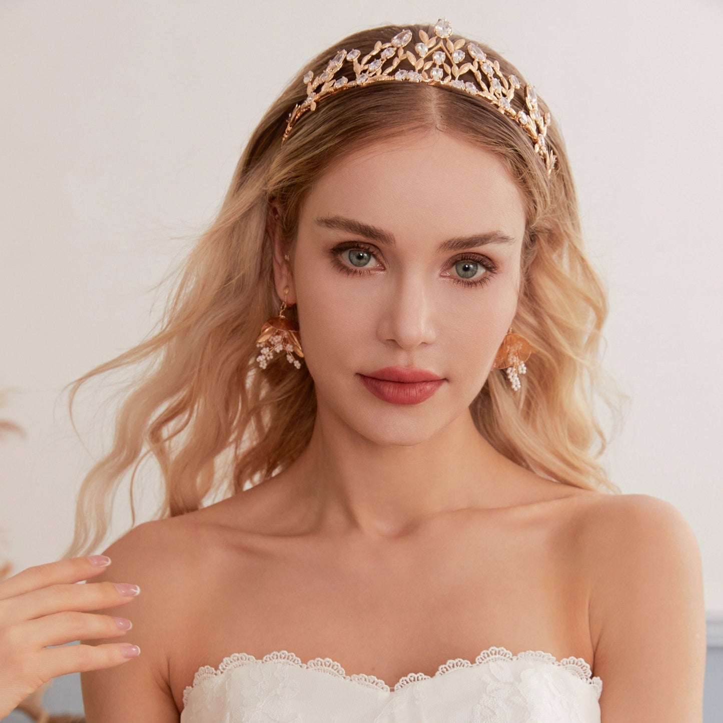 Victoria | Gold Crystal Bridal Crown Tiara - Handcrafted with attention to detail, this unique crown features delicate gold metal leaves intricately arranged alongside an array of dazzling rhinestone flowers in various sizes. The combination of gold and crystals creates a vintage-inspired woodland feel.