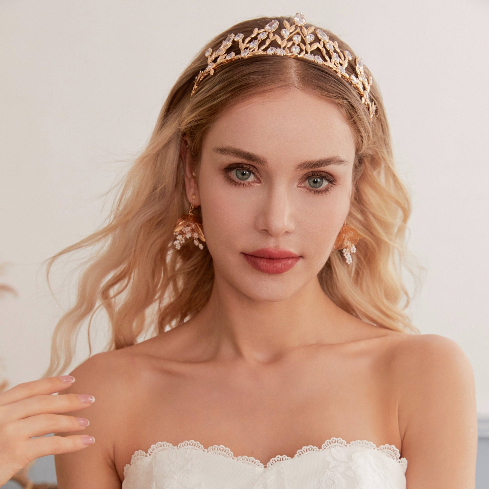 Victoria | Gold Crystal Bridal Crown Tiara - Handcrafted with attention to detail, this unique crown features delicate gold metal leaves intricately arranged alongside an array of dazzling rhinestone flowers in various sizes. The combination of gold and crystals creates a vintage-inspired woodland feel.