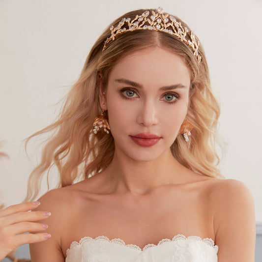 Victoria | Gold Crystal Bridal Crown Tiara - Handcrafted with attention to detail, this unique crown features delicate gold metal leaves intricately arranged alongside an array of dazzling rhinestone flowers in various sizes. The combination of gold and crystals creates a vintage-inspired woodland feel. 