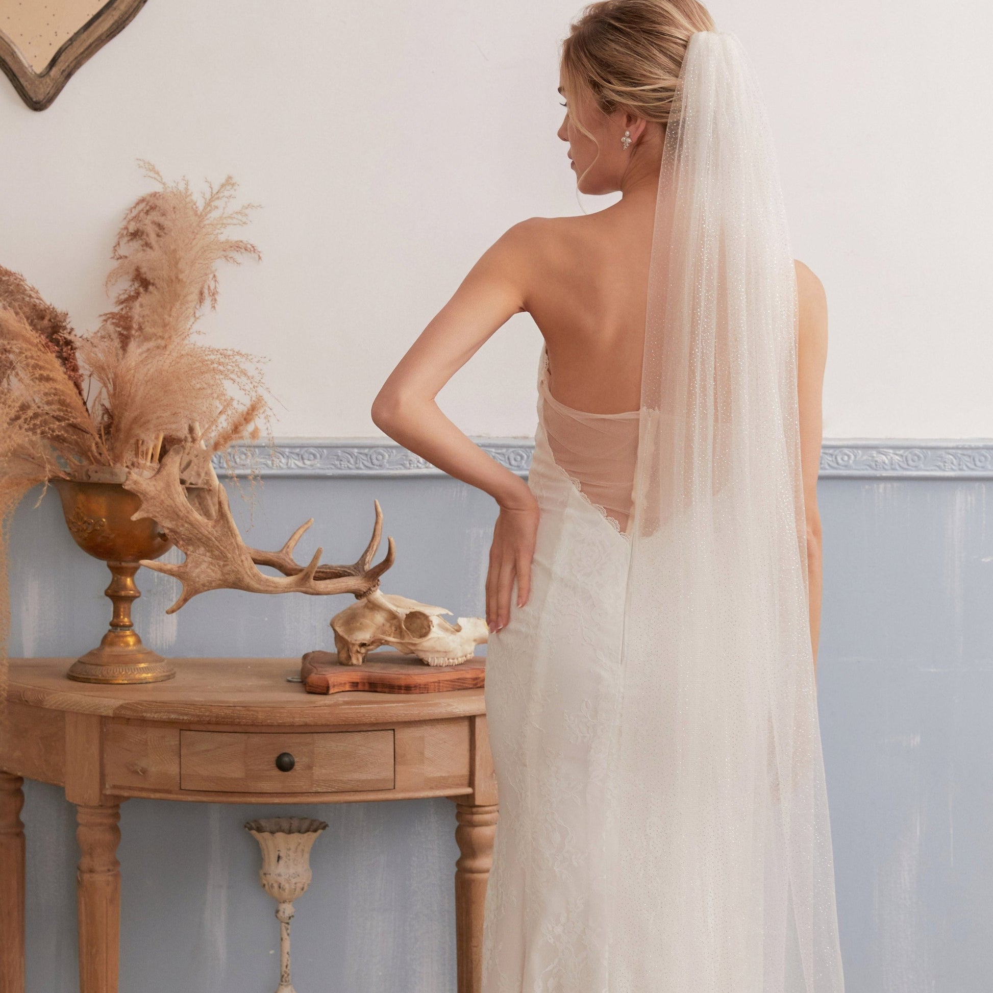 Luxurious single-layer cathedral wedding veil crafted from delicate sparkle glitter tulle. With an ivory base (also available in white and champagne), it features a simple cut edge for an elegant and timeless style that complements any bridal look.  At 3 meters long, this veil is the perfect bridal accessory to enhance any wedding dress. Offering a subtle sparkle without any fuss, it adds a touch of glamour to your special day.
