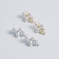 These stunning earrings feature leaf-like zirconia crystals that shimmer beneath three delicate pearls, evoking the graceful beauty of blooming flowers.