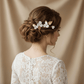 Bride wearing gold porcelain flower hair accessory in an elegant wedding updo