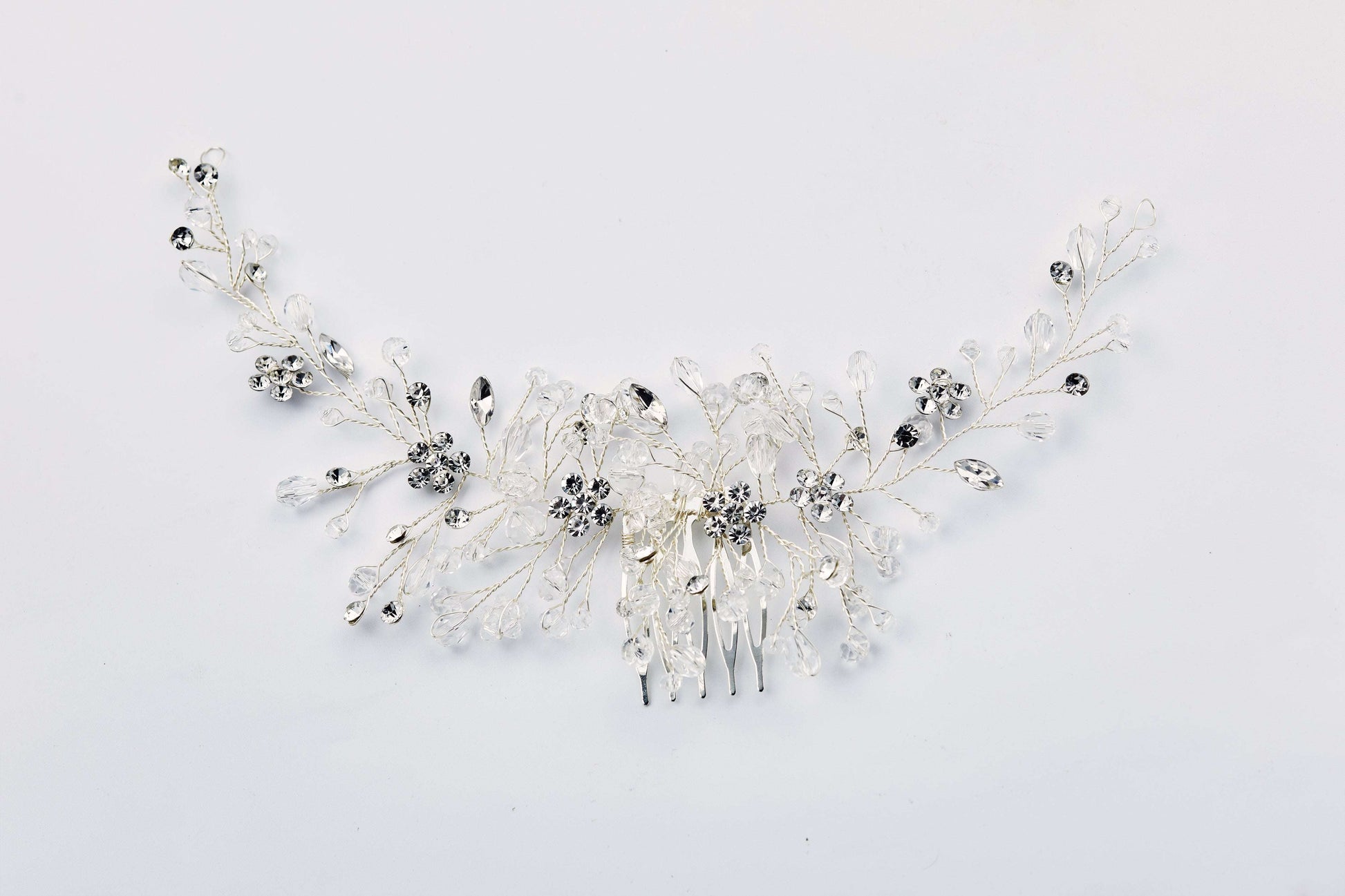 Sparkly rhinestone flower hair comb on a black background