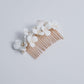 A delicate and romantic white porcelain bridal hair comb, handcrafted with love. This exquisite bridal hairpiece features a cluster of beautiful flowers adorned with lustrous natural freshwater pearls, arranged in a full design.