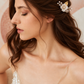 Bride wearing the white flower and crystal hair comb in a half-up hairstyle, side portrait.