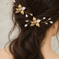 Side-rear view of two gold pearl and CZ leaf hair combs above loose bridal waves