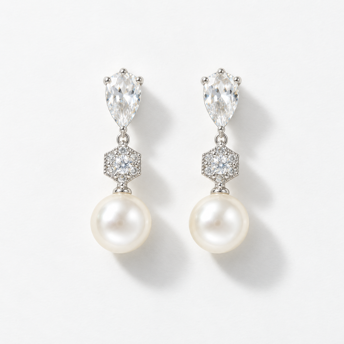 Pair of silver pear-shaped crystal and pearl drop earrings, front view