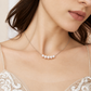 Close-up of a bride wearing a five-pearl silver-plated necklace with a lace wedding dress