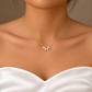 Front view of a gold-coloured flower petal necklace worn with a white satin bridal gown