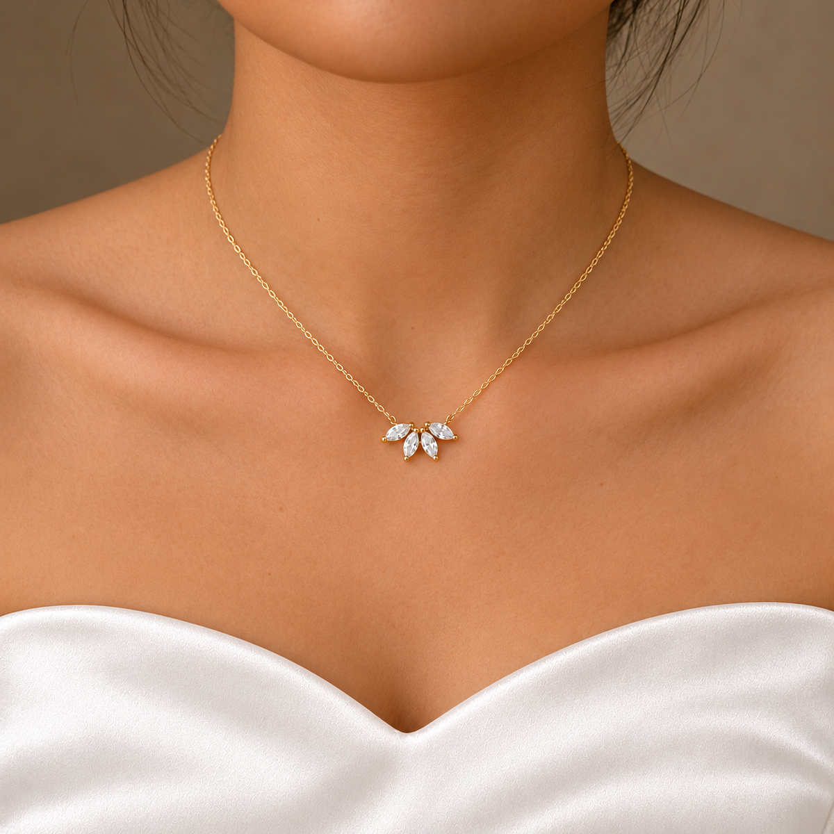 Front view of a gold-coloured flower petal necklace worn with a white satin bridal gown