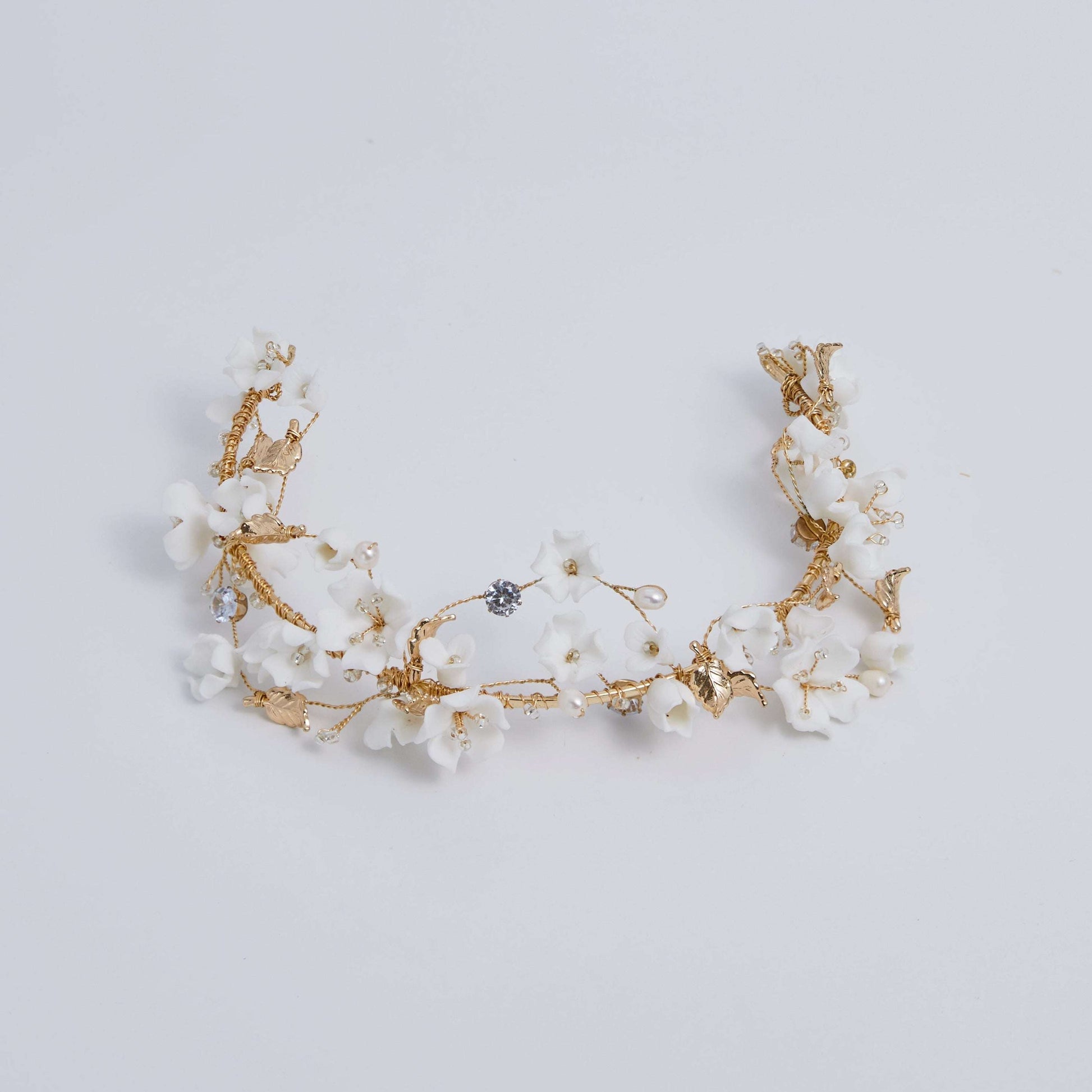 This beautifully hand-sculpted clay & pearl crown features individually crafted cherry blossom flowers, dainty freshwater pearls, and crystals. The result is a full, textured headband that makes a statement while remaining incredibly feminine.
