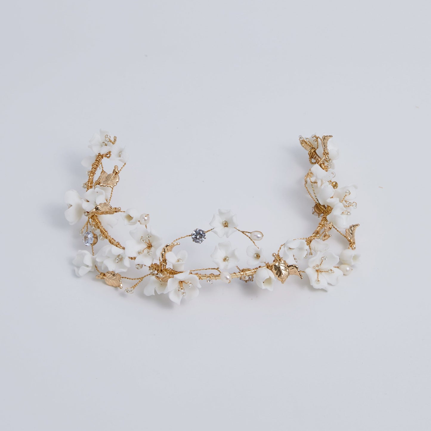 This beautifully hand-sculpted clay & pearl crown features individually crafted cherry blossom flowers, dainty freshwater pearls, and crystals. The result is a full, textured headband that makes a statement while remaining incredibly feminine.