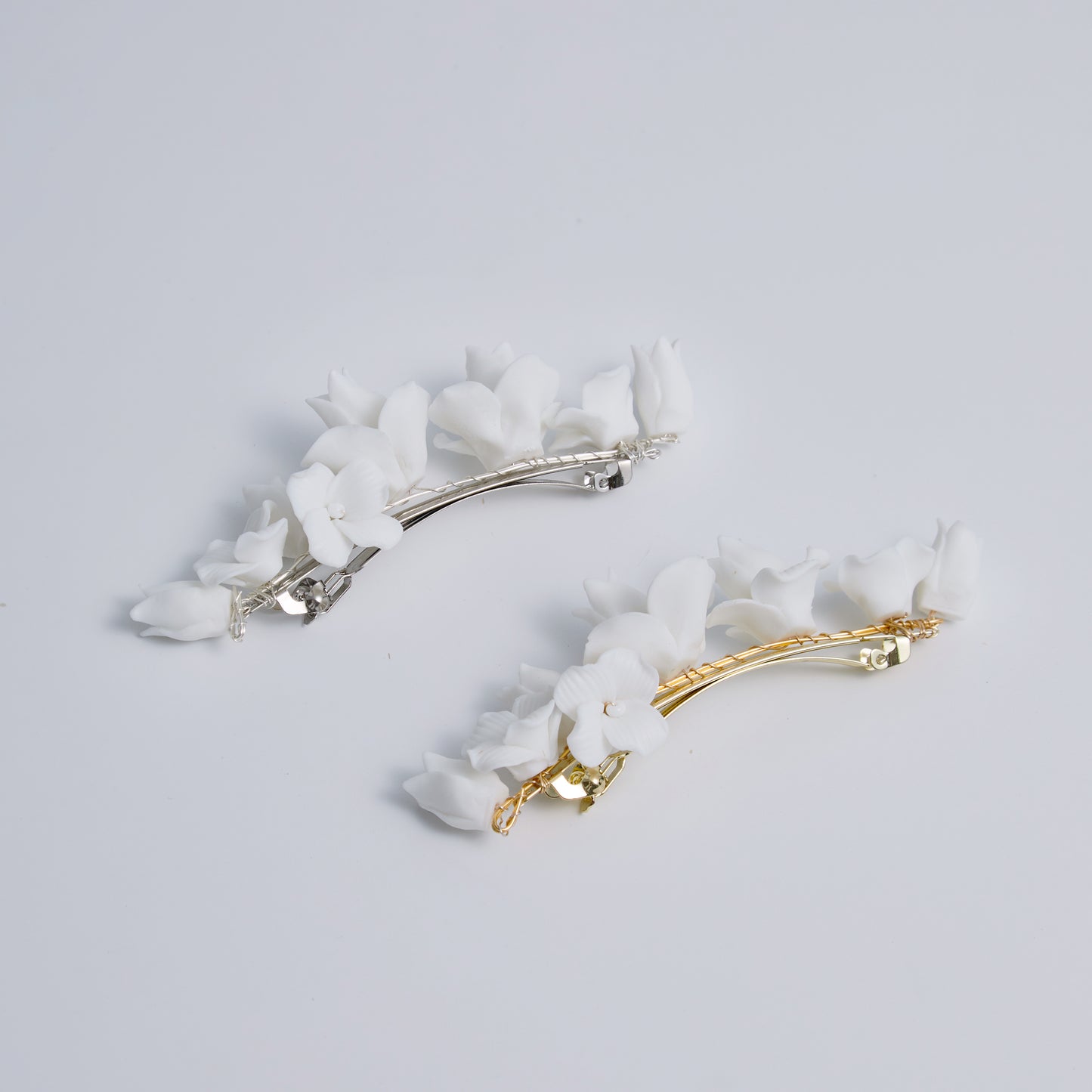 This statement bridal hair clip features carefully handcrafted white porcelain flowers and blossoms, adding an elegant and romantic touch to your hairstyle. It effortlessly enhances any bridal look, creating a timeless style.