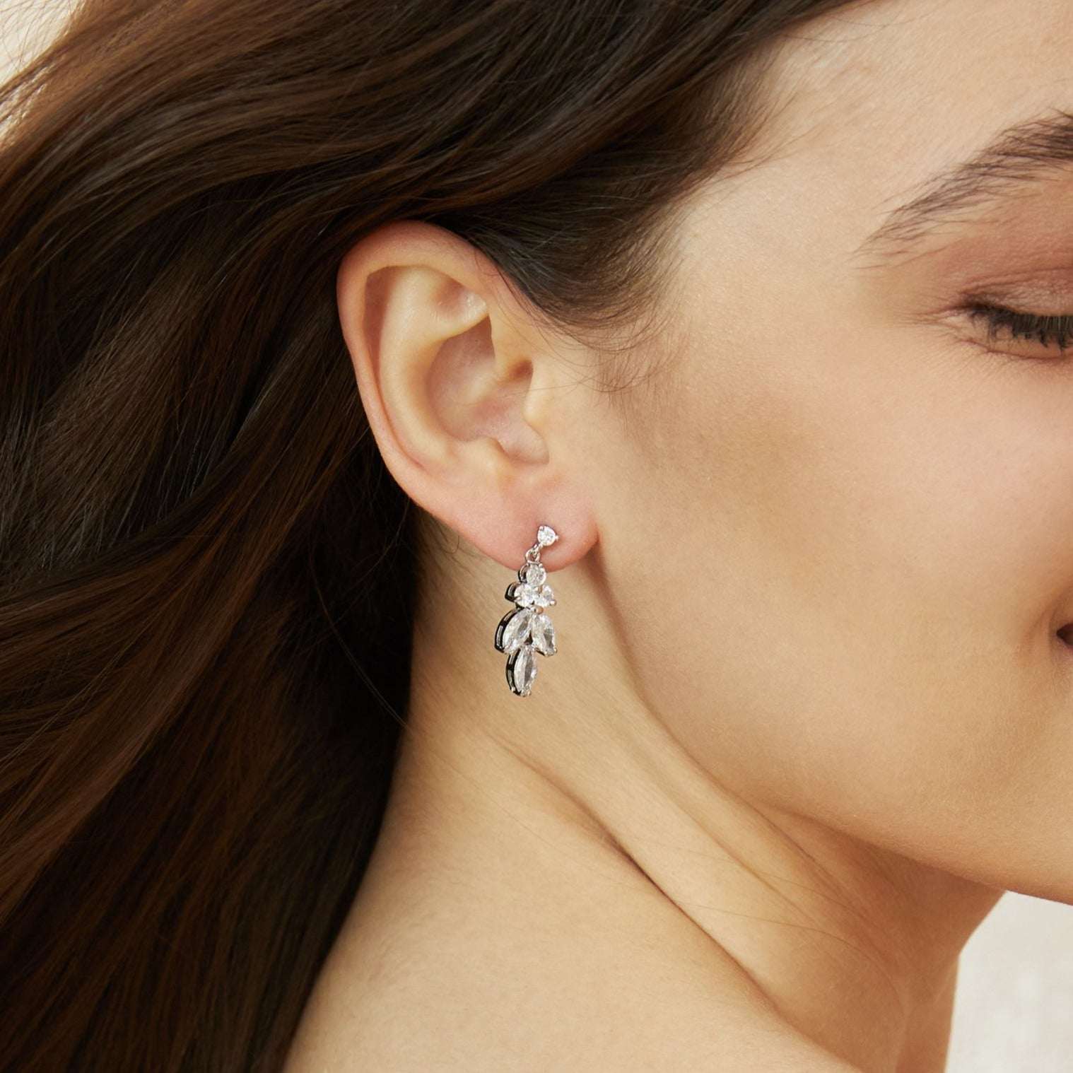 Side profile of a bride wearing elegant silver crystal drop earrings