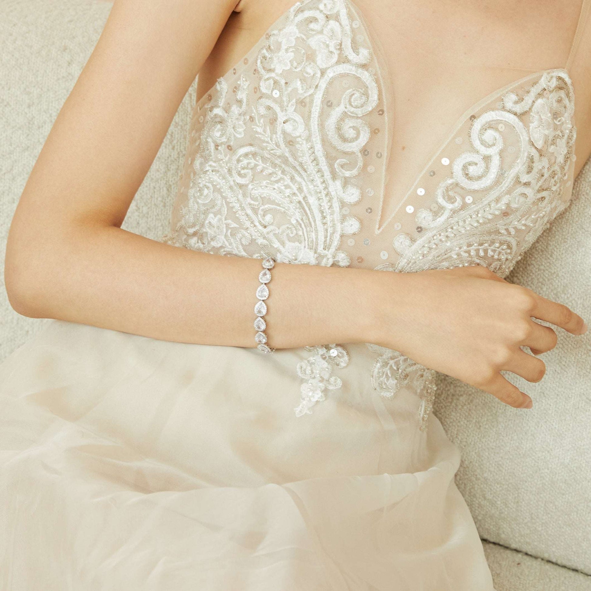 Bride wearing the minimalist teardrop crystal bridal earrings with a wedding dress