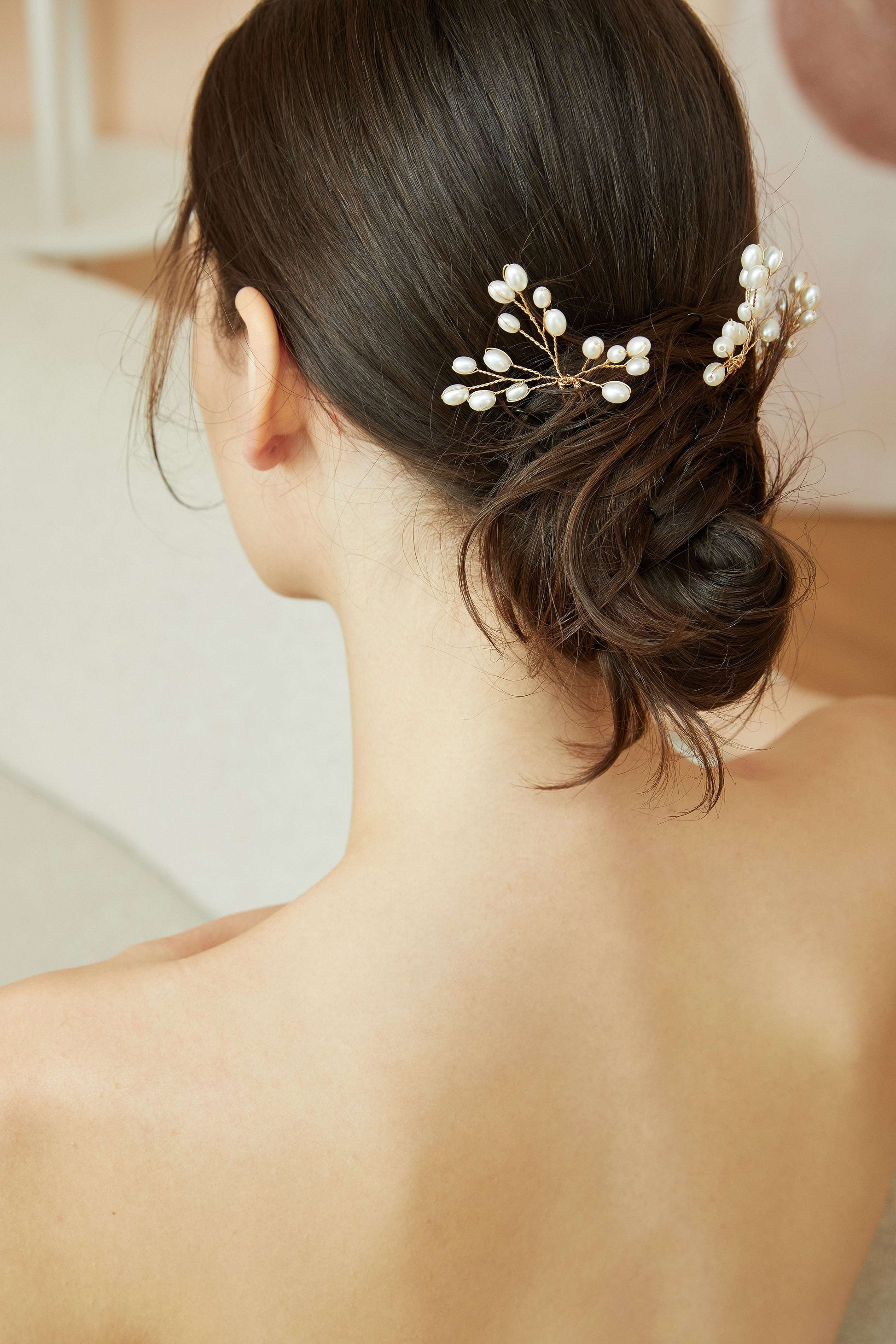 Back view of a bride with a romantic updo and pearl hair accessories