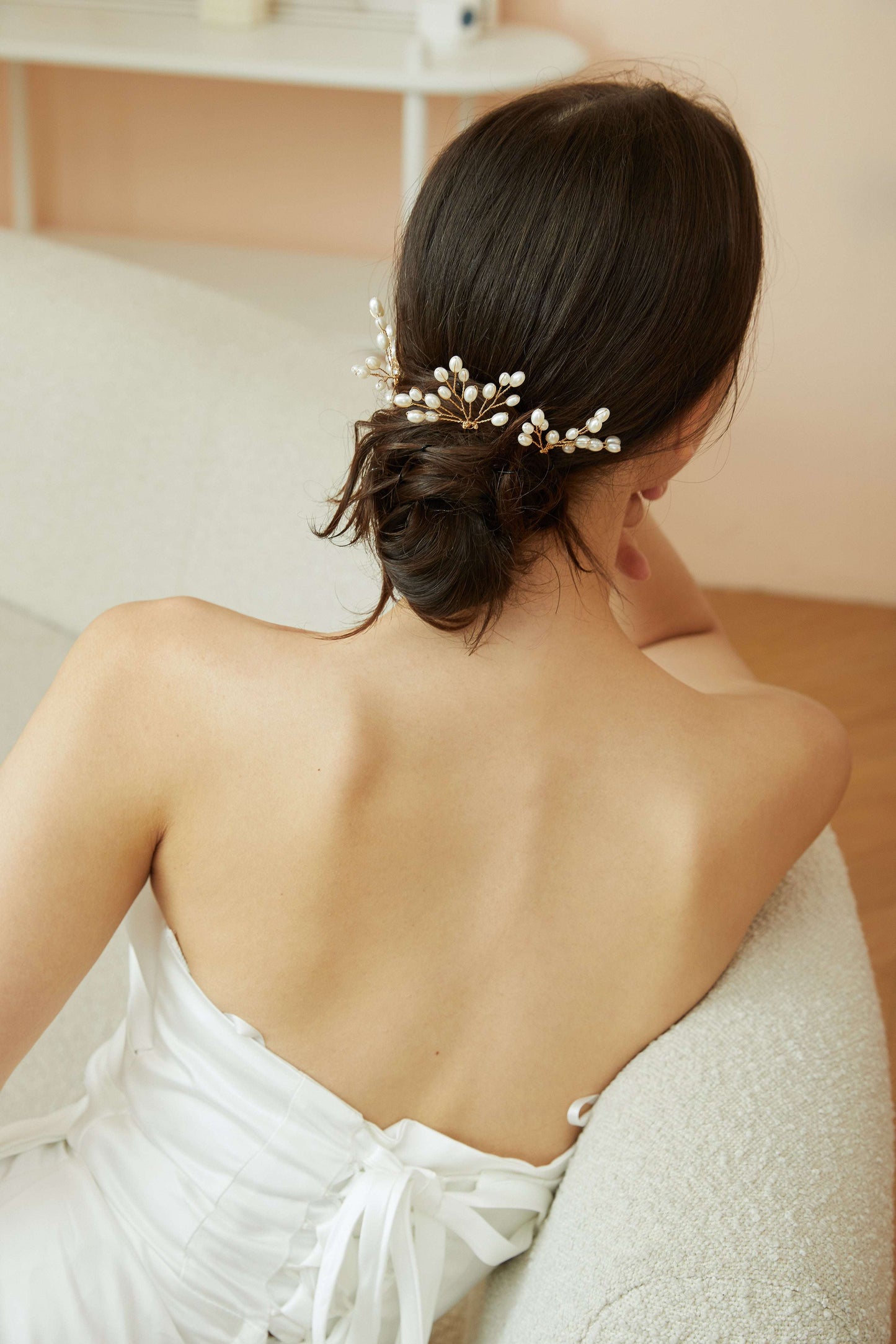 Model wearing delicate pearl hair pins in an elegant updo