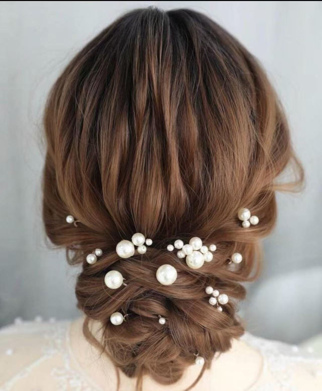Close-up of a bride wearing a minimalist silver pearl hair pin in an elegant updo