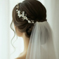 Bridal side profile with white porcelain flower pearl comb in low bun hairstyle
