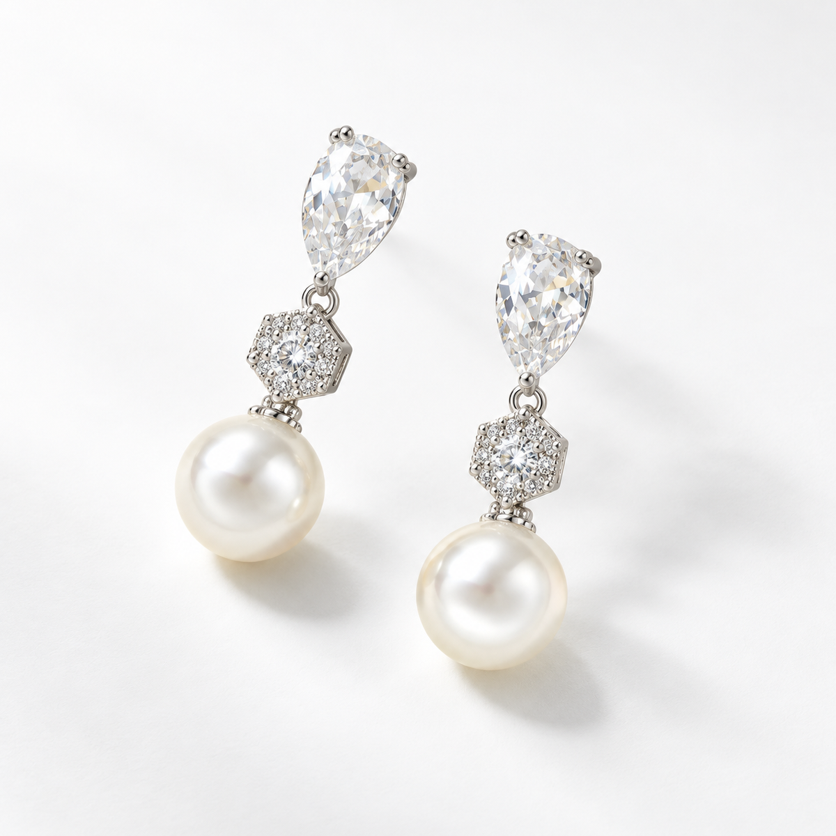 Silver crystal and pearl drop earrings photographed at an angle