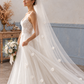 Side view of a bride wearing a sheer white wedding veil with scattered fabric flowers