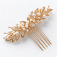 Angled view of the openwork gold leaf bridal hair comb showing clear cubic zirconia stones, white bead accents and comb teeth