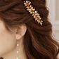 Close-up of a gold leaf bridal hair comb positioned along a twisted half-up hairstyle