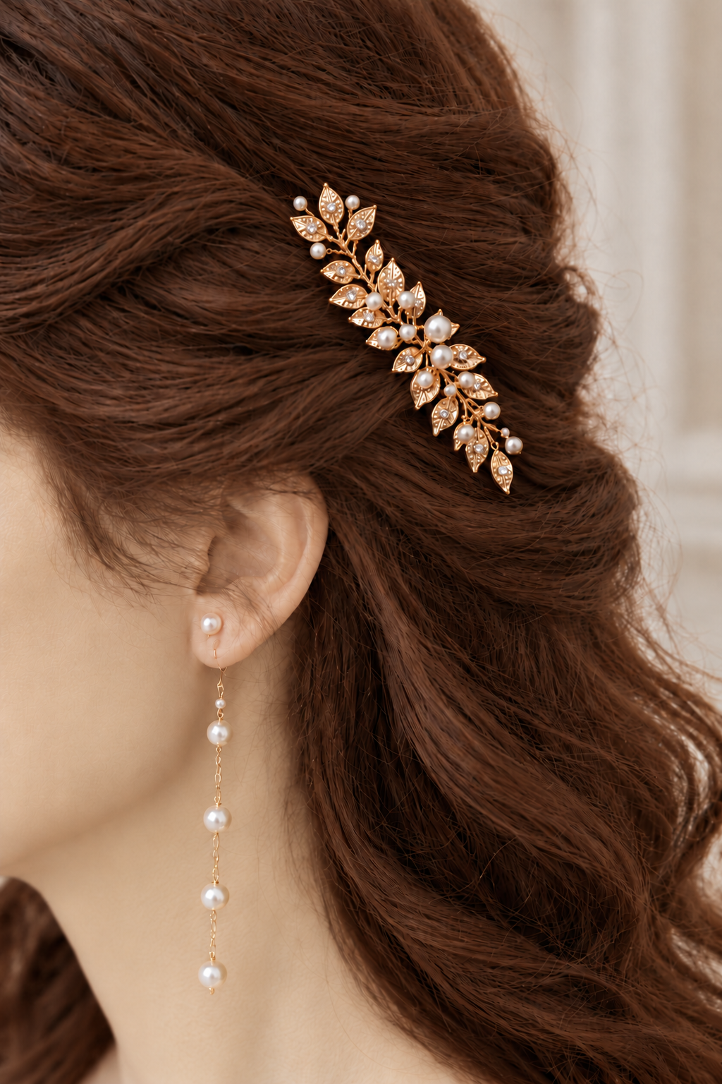 Close-up of a gold leaf bridal hair comb positioned along a twisted half-up hairstyle