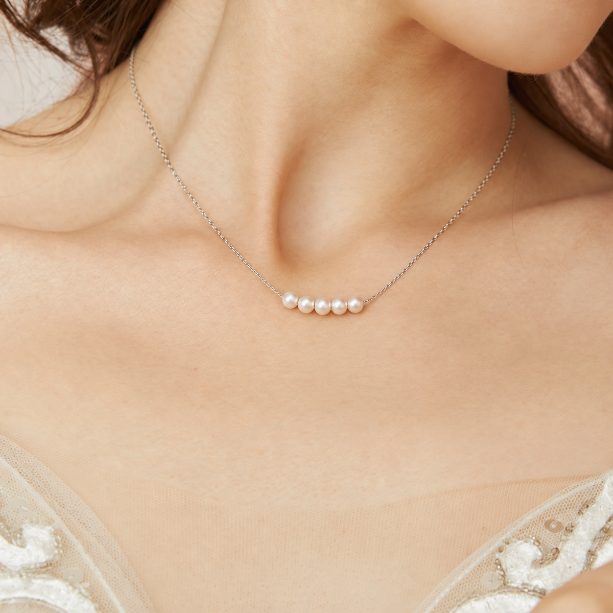Bride wearing a silver-plated necklace with five natural pearls centred at the neckline