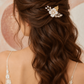 Rear view of a bride wearing the white flower and crystal hair comb in long brown hair.