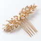 Diagonal product view of the gold leaf bridal comb with branching white bead details