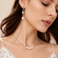 Close-up of a bride wearing freshwater pearl chain-drop earrings and a five-pearl necklace