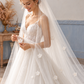 Bride holding the sheer tulle of a floral wedding veil, showing the layered white flower details