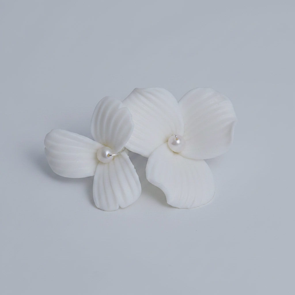 ANNA white porcelain flower and pearl bridal drop earrings laid flat