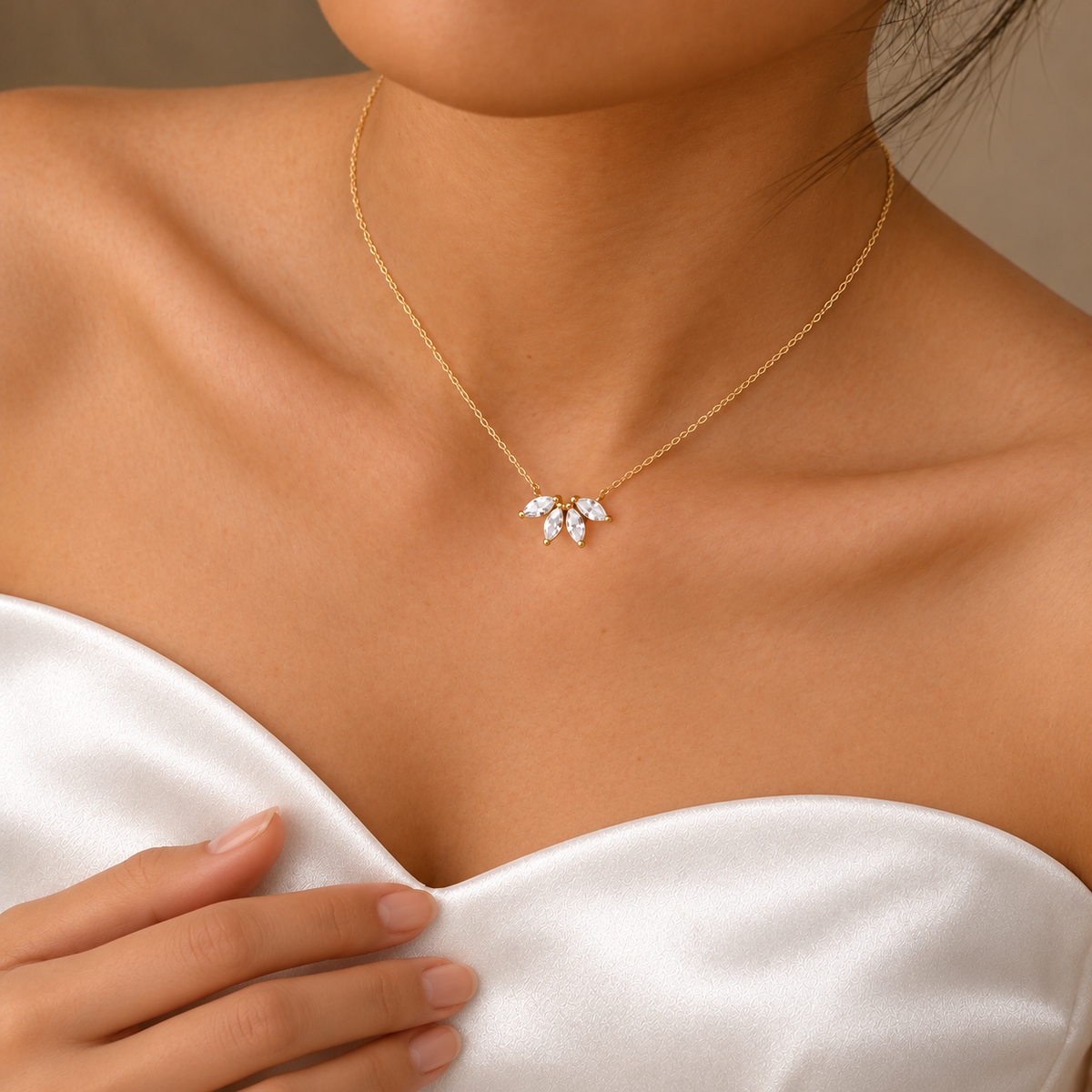 Gold-coloured floral pendant necklace above a white satin sweetheart neckline