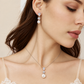 Bride wearing silver crystal and pearl drop earrings with a matching pendant necklace