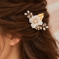 Close-up side view of the white flower and crystal bridal comb worn in brown hair.