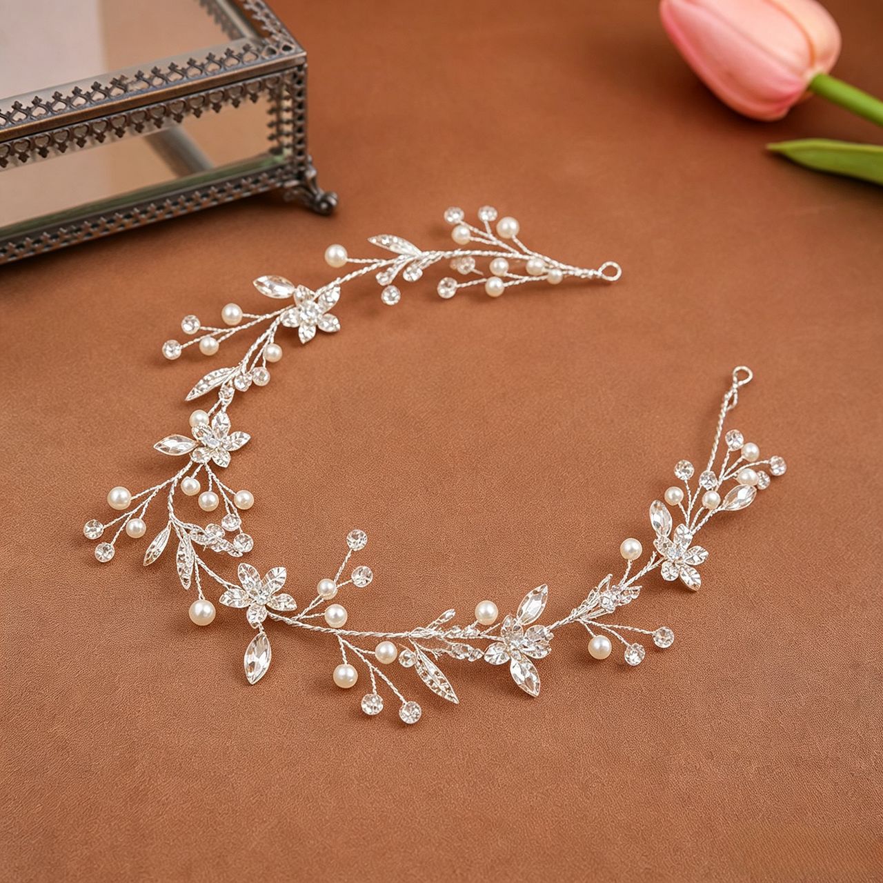 Silver pearl crystal bridal hair vine with flexible wire branches and floral crystal details on brown background