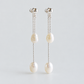 Front view of the pair of freshwater pearl tassel earrings on a pale grey background