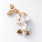 Angled product view of the white ceramic flower hair clip with 14K gold-plated detailing