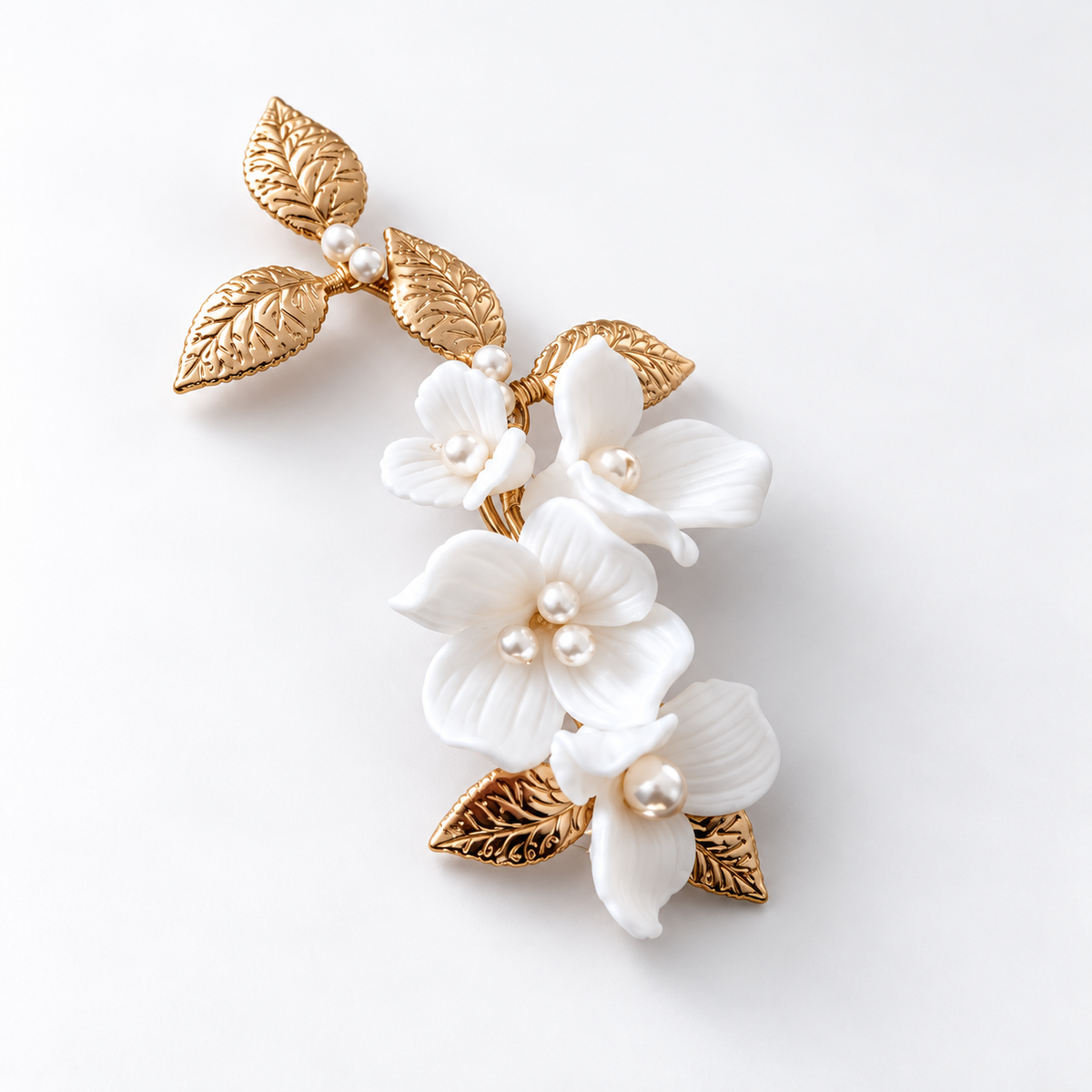 Angled product view of the white ceramic flower hair clip with 14K gold-plated detailing