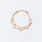 Overhead view of a delicate double-strand gold pearl bracelet