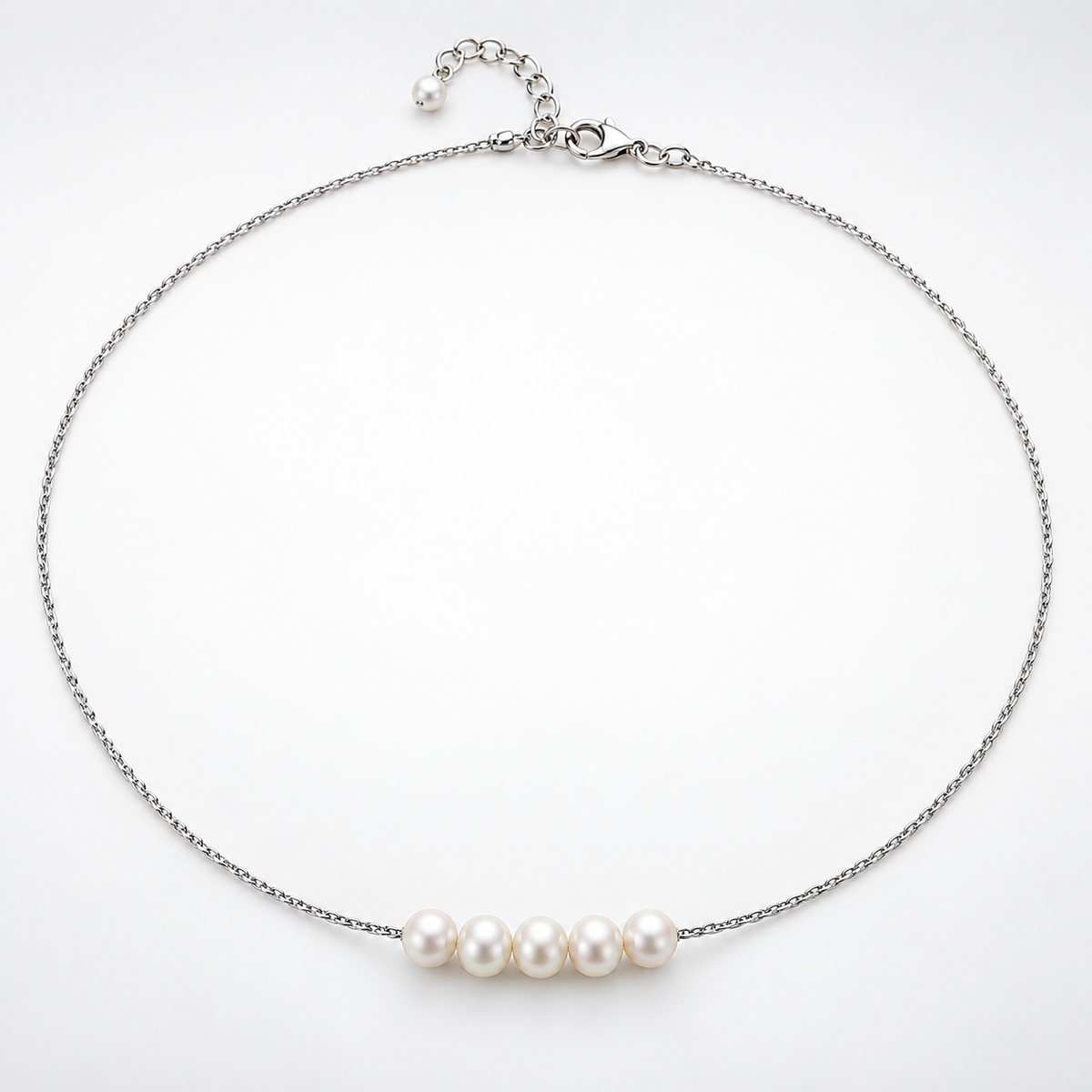 Silver-plated necklace laid in a circle, showing five natural pearls, clasp and extender chain