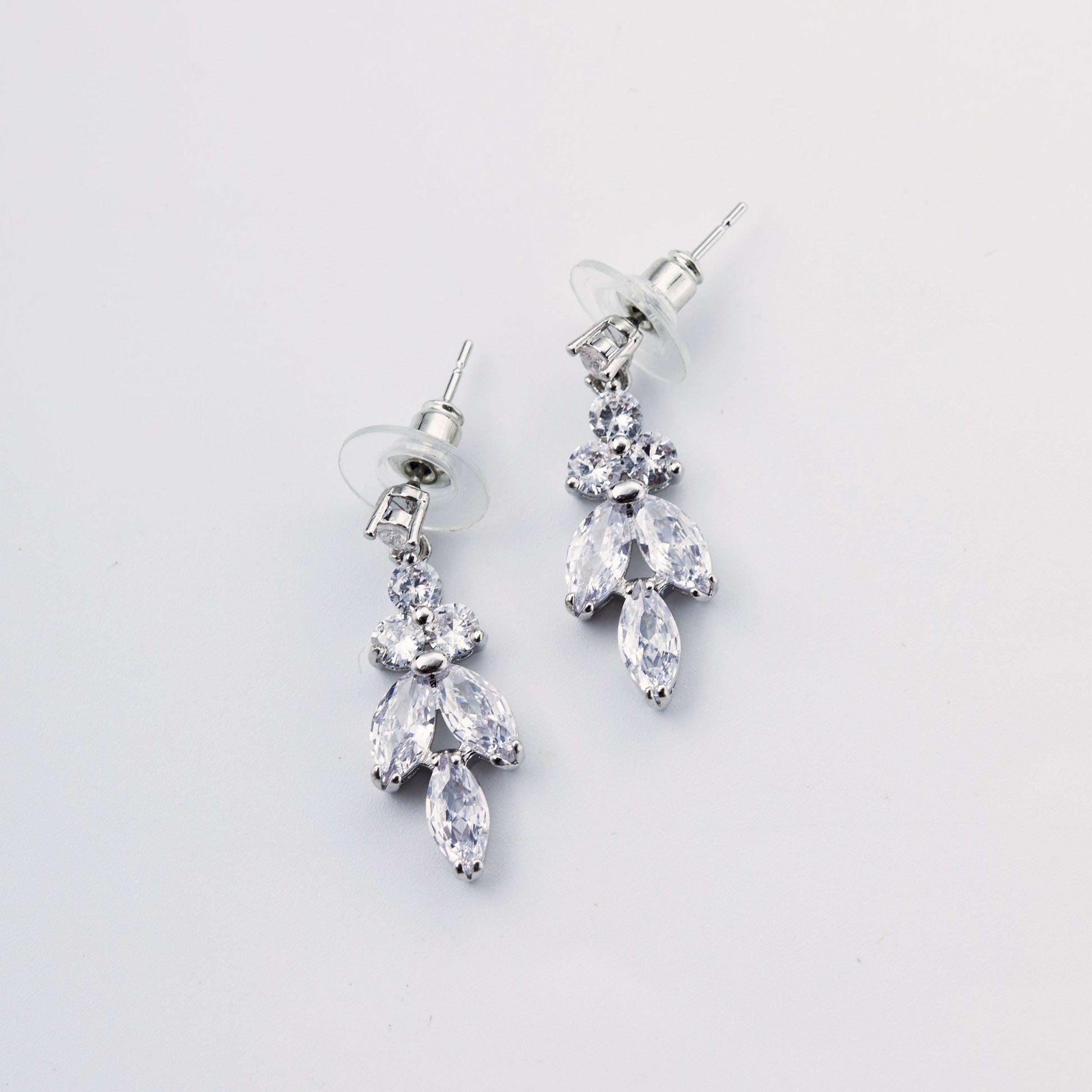 Pair of silver leaf drop earrings with Swarovski crystals on a white background