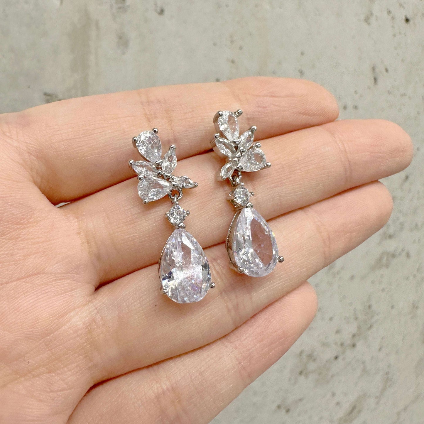 EVIE lightweight crystal bridal earrings held in hand to show scale