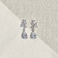 Close-up of EVIE floral cluster and pear-shaped CZ crystal earrings