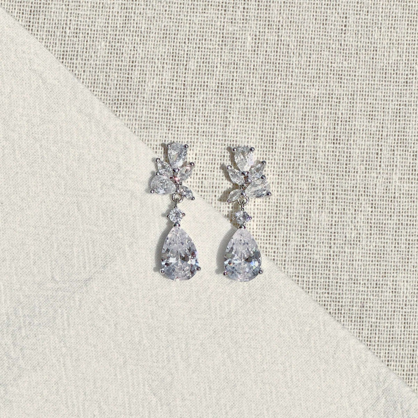 Close-up of EVIE floral cluster and pear-shaped CZ crystal earrings